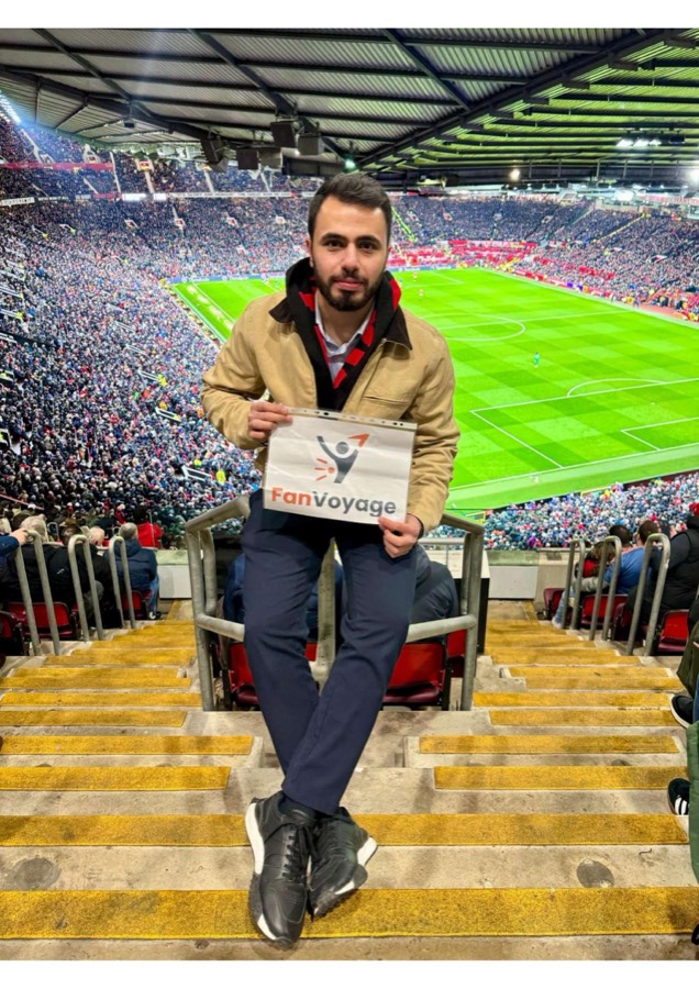A FanVoyage traveller holding the FanVoyage sign at Old Trafford